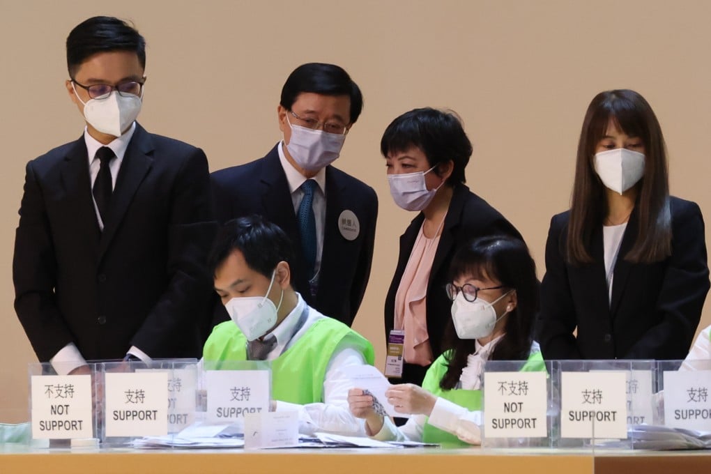 John Lee (second left, standing) watches the election count in May. Photo: Felix Wong