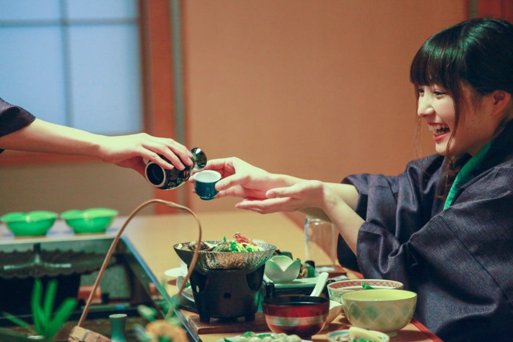A guest at a Japanese inn enjoys a cup of sake. Sales of the Japanese liquor are falling and the national tax agency has launched a contest for ideas to promote sake drinking to young people. Photo: Getty Images
