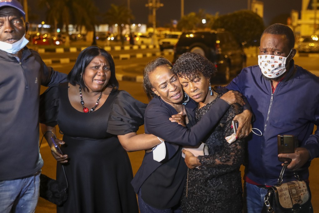 Mourners comfort each other as the hearse passes by carrying the remains of the former Angolan president Jose Eduardo dos Santos at the airport in Luanda, Angola on Saturday. Photo: EPA-EFE