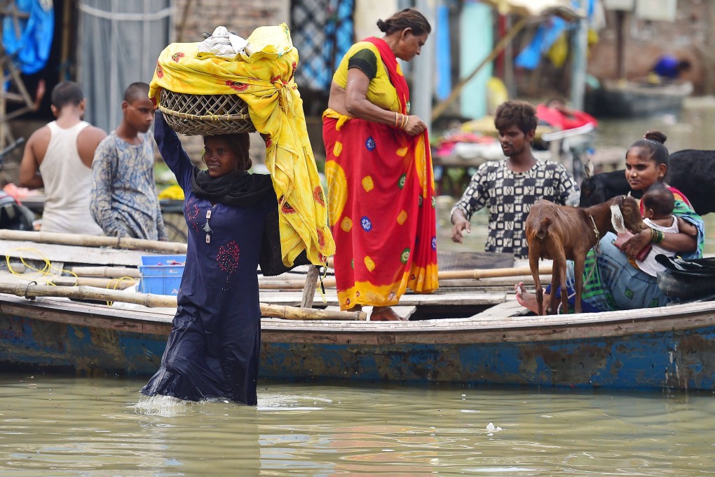 Flood-affected residents move their belongings to drier ground at Daraganj area in Allahabad. Photo: AFP