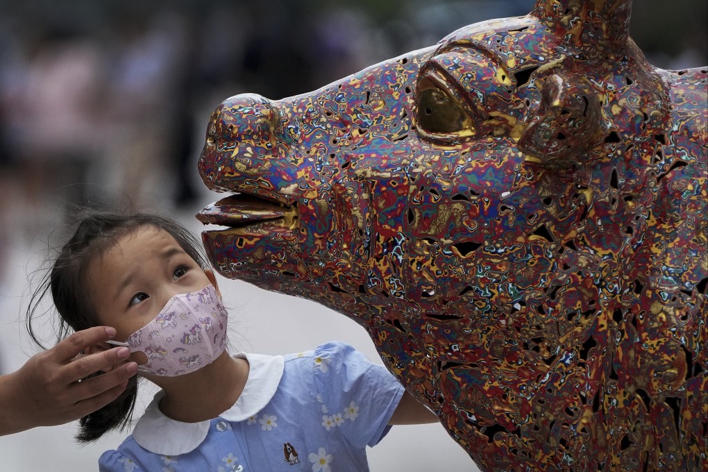 A child takes a look at a bull sculpture in Beijing. Photo: AP Photo