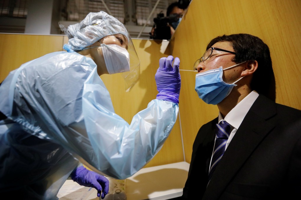 A medical worker wearing protective gear practises taking a swab sample at a coronavirus testing centre in Tokyo’s Narita International Airport in November 2020. Photo: Reuters