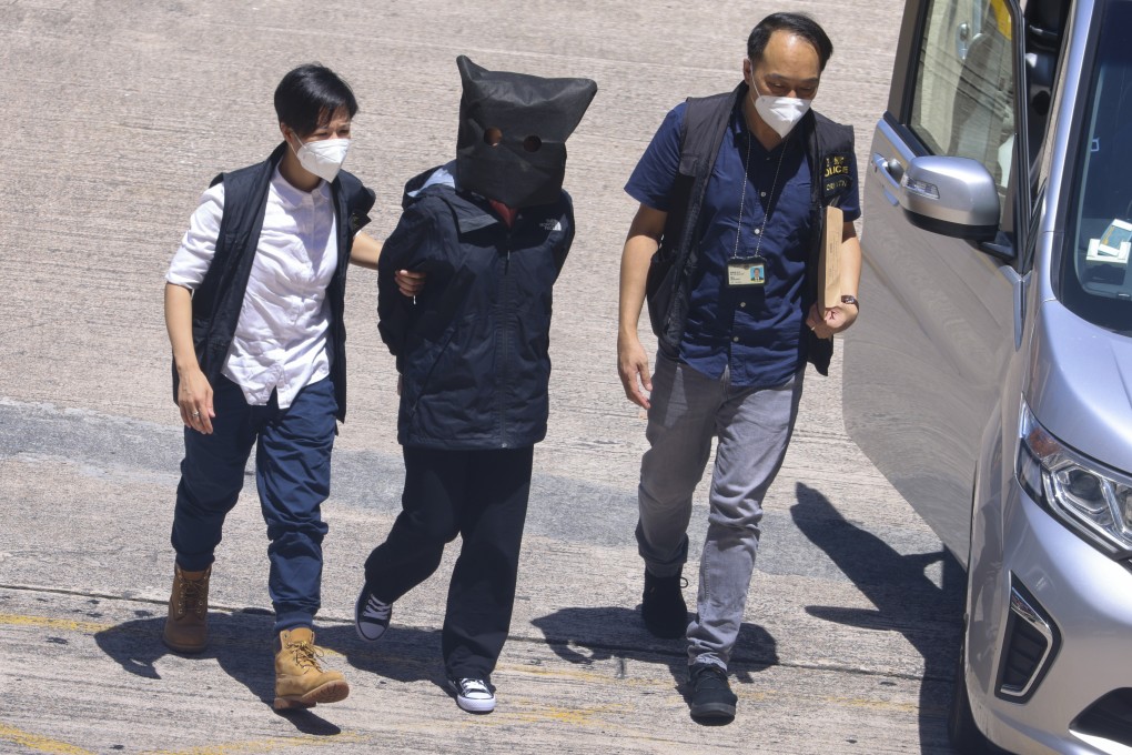 Quinn Moon is escorted by officers to Tin Shui Wai Police Station after being handed over by mainland authorities on Monday. Photo: Dickson Lee