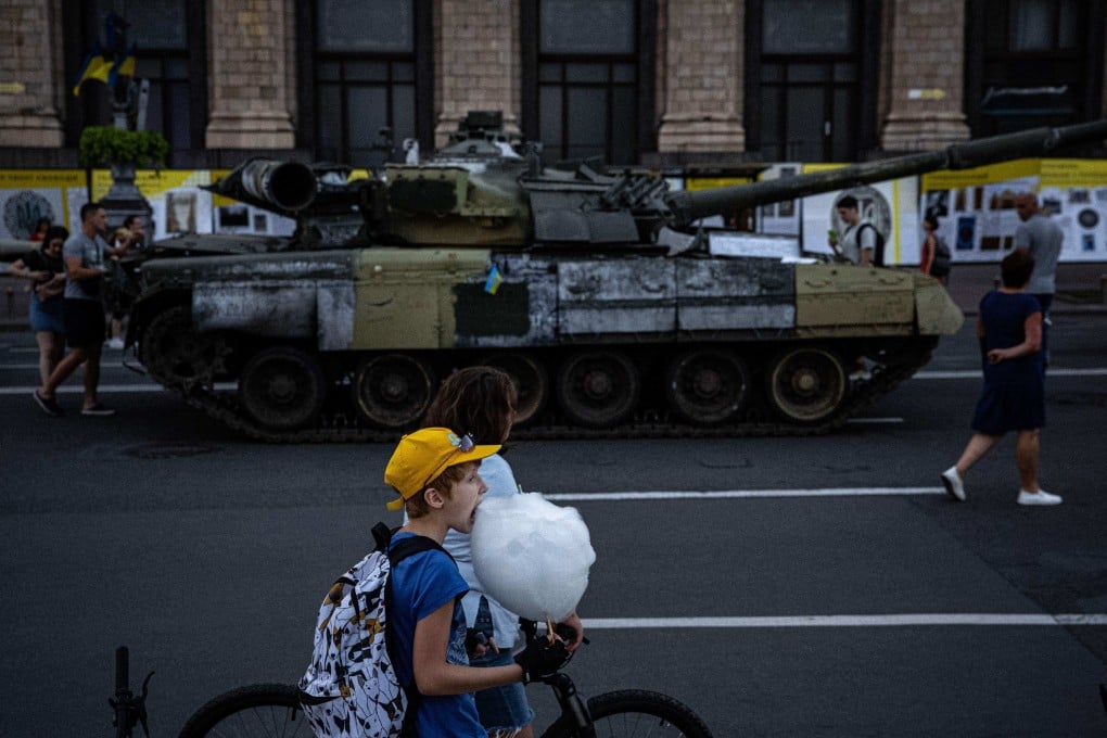 A boy eats candy floss next to a destroyed Russian tank displayed on Khreshchatyk Street, in Kyiv, on August 23. The street was turned into an open-air military museum ahead of Ukraine’s Independence Day on August 24. Photo: AFP