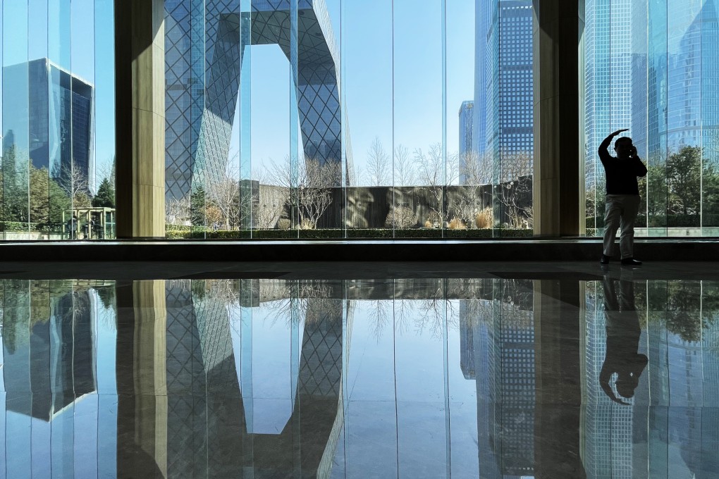 A man talks on his mobile phone in an office building in the central business district of Beijing on March 3, 2022. Photo: Simon Song