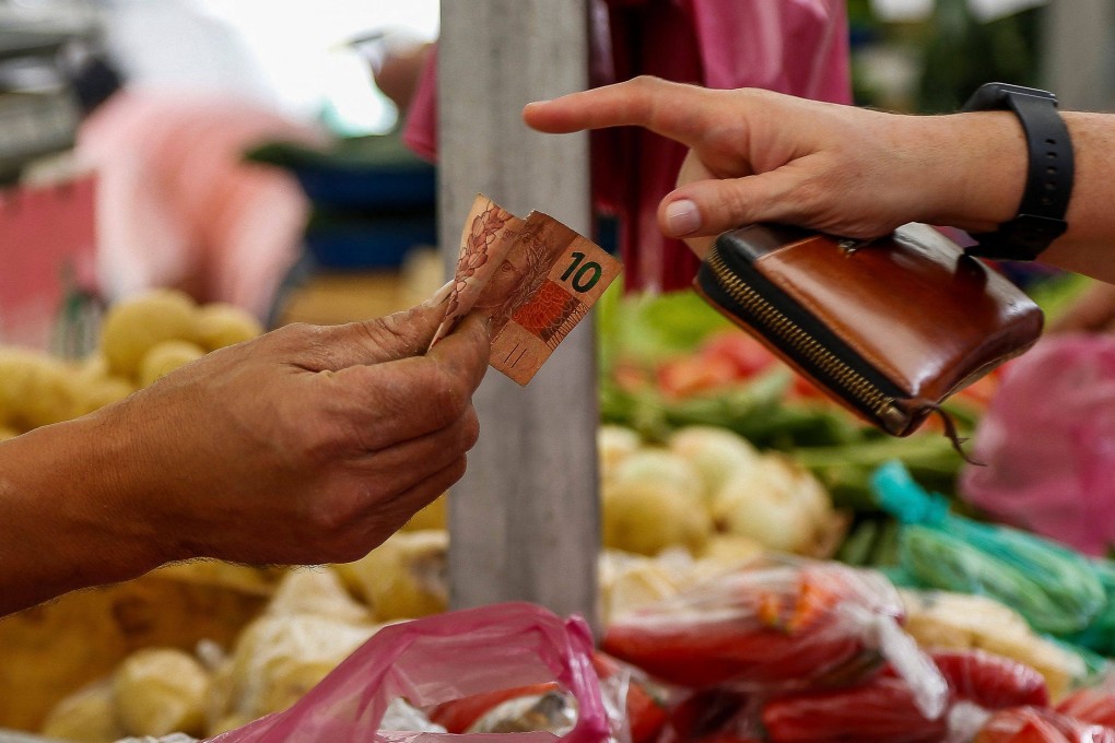 A customer pays in cash at a vegetables stall at a street market in Sao Paulo, Brazil, on August 25. Shocks to the global system resulting from pandemic-induced supply interruptions followed by the Ukraine war could persist for years rather than months. Photo: AFP
