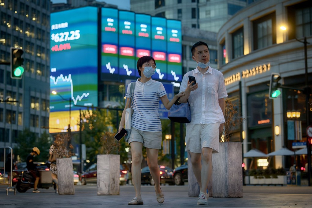 People walk in front of the large screen showing the latest stock exchange data in Shanghai on Monday. Photo: EPA-EFE