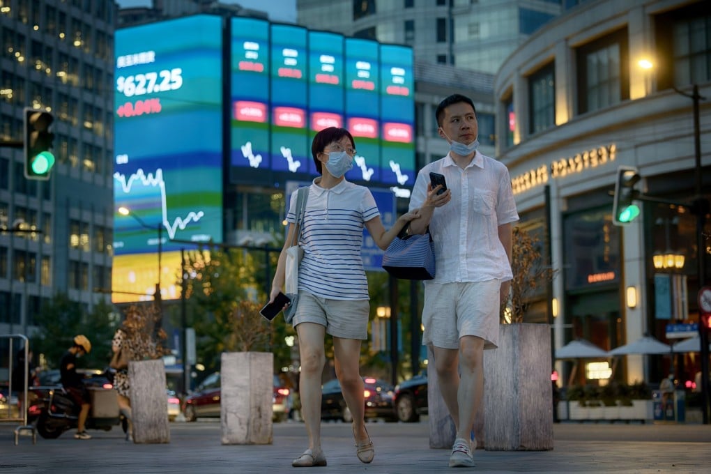 People walk in front of the large screen showing the latest stock exchange data in Shanghai on Monday. Photo: EPA-EFE