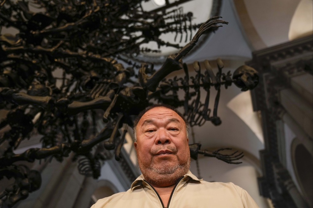 Chinese artist Ai Weiwei poses in front of his glass sculpture La Commedia Umana at the San Giorgio deconsecrated church in Venice, Italy on Friday. Photo: AP