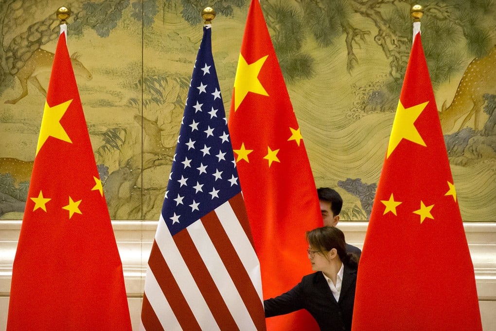 Members of staff adjust the national flags ahead of US-China trade talks in Beijing. Photo: AP