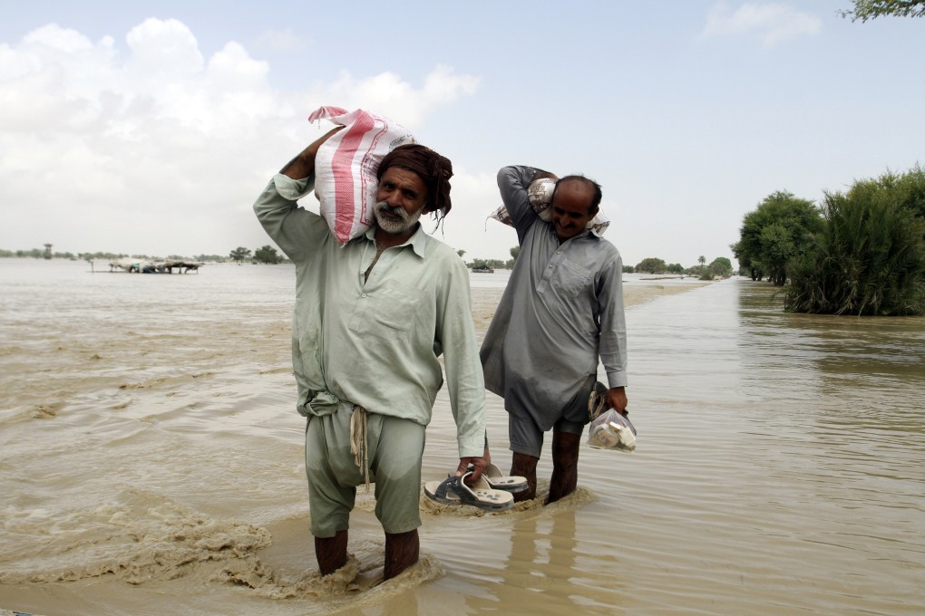 Pakistani men receive food, distribute by Pakistani Army troops in a flood-hit area in Rajanpur, district of Punjab, Pakistan on Saturday. Photo: AP