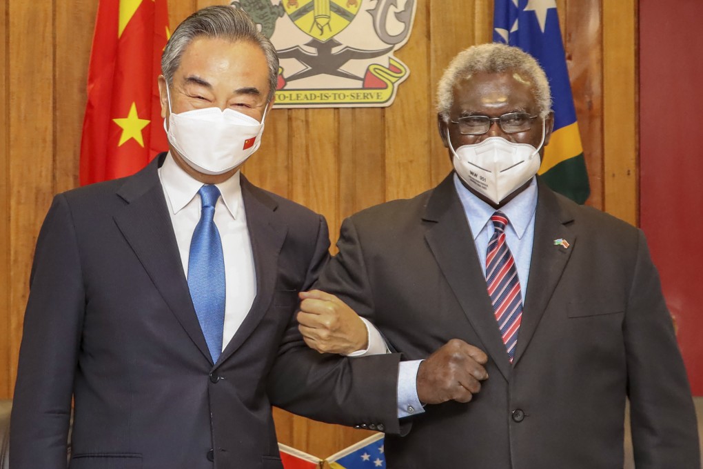 Solomon Islands Prime Minister Manasseh Sogavare locks arms with visiting Chinese Foreign Minister Wang Yi in Honiara in May. The two countries signed a security pact earlier this year. Photo: Xinhua via AP