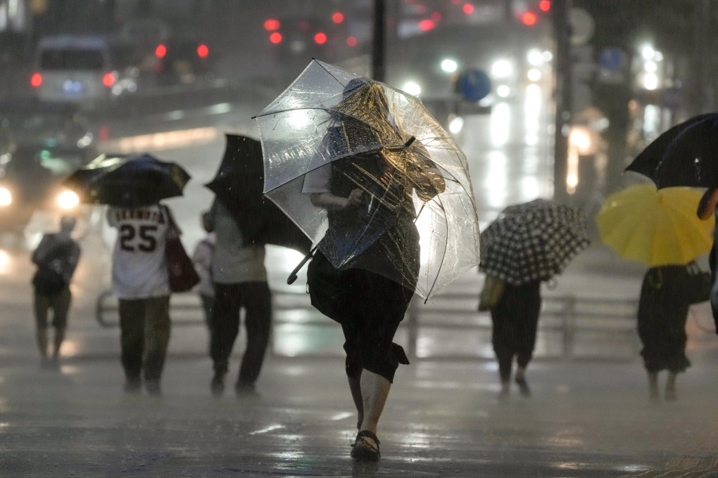 Pedestrians struggle against heavy rain and strong winds in Japan amid a typhoon earlier this month. Photo: EPA-EFE