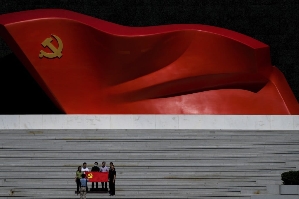 Visitors pose for a photo near a flag sculpture at the Museum of the Communist Party of China in Beijing on Wednesday. The party’s key congress begins on October 16. Photo: AP
