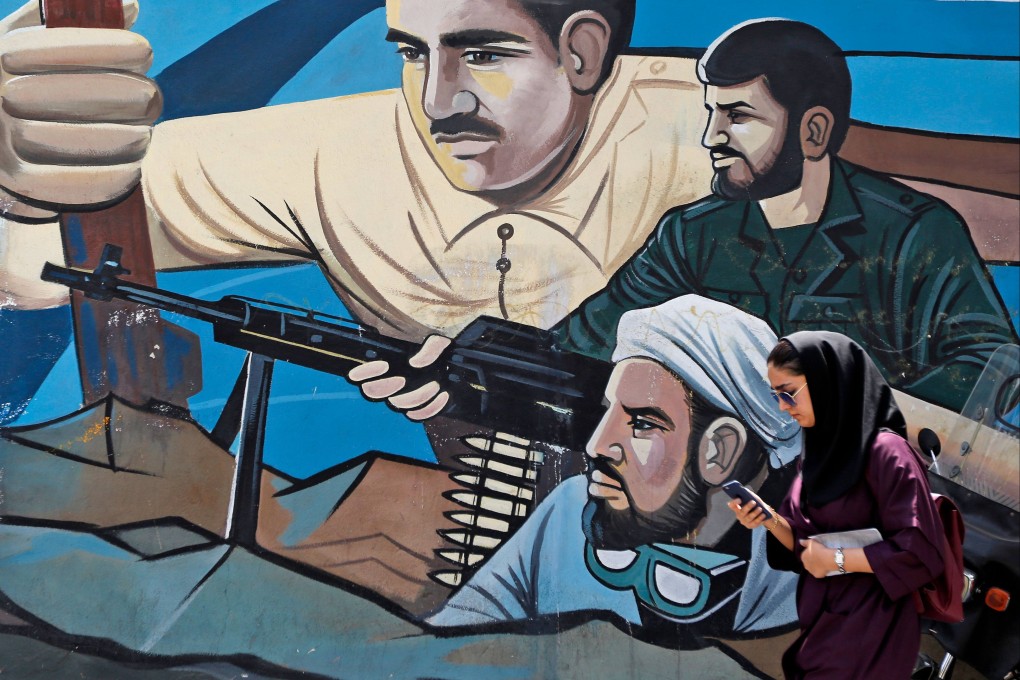 A woman walks past a graffiti mural depicting scenes of fighters painted along Palestine Square in the Iranian capital Tehran. Photo: AFP