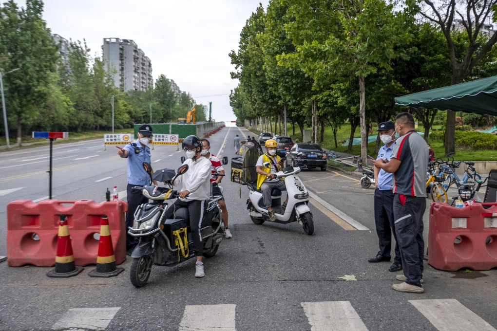 Police officers in Chengdu, China perform checks on a road ahead of a Covid-19 lockdown on Thursday. Photo: AFP