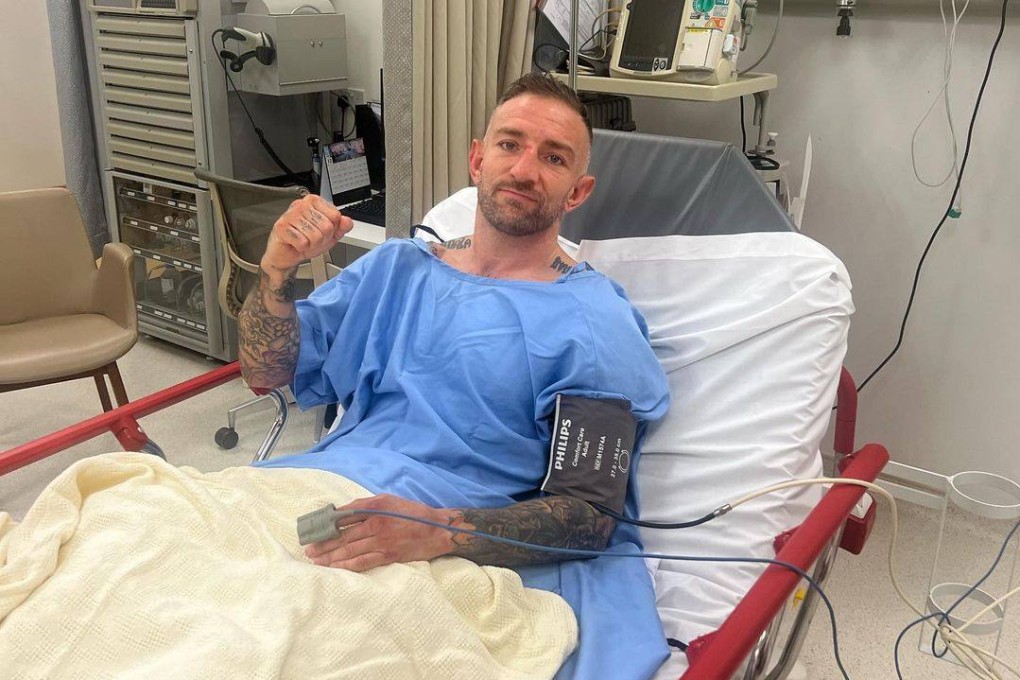 Liam Harrison poses in a hospital bed in Singapore after suffering a leg injury in the first round of a title fight with ONE bantamweight Muay Thai champion Nong-O Gaiyanghadao. Photo: Instagram/@liambadco