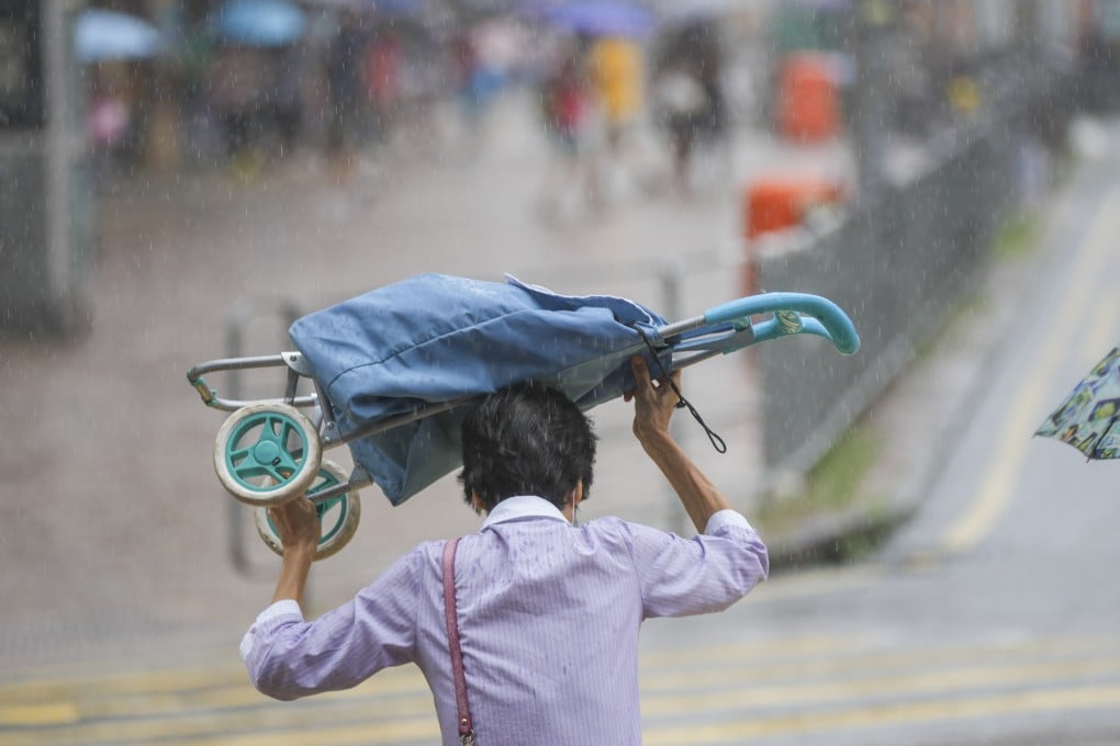 A makeshift ‘umbrella’ is deployed as a man is caught in a downpour last month, one of the wettest Augusts in more than a century. Photo: Sam Tsang.