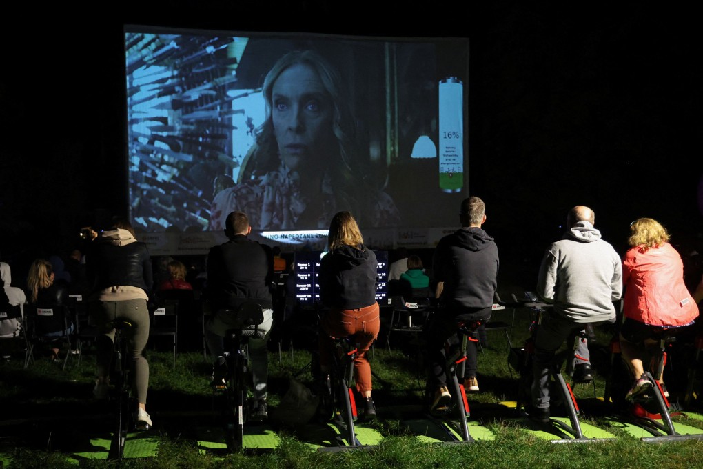 People pedal stationary bikes to generate energy at an outdoor cinema in a park in Warsaw, Poland. Photo: Reuters