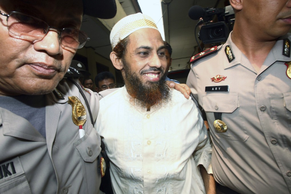 Terrorist suspect Umar Patek is escorted by police officers as he arrives to testify for his wife, Ruqayyah binti Husein Luceno, who is on trial for immigration violations, at a district court in Jakarta, Indonesia on November 29, 2011. Photo: AP/File