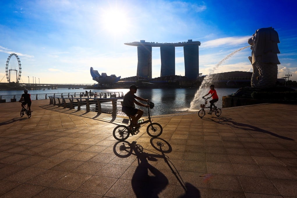People cycle through Merlion Park in Singapore with the Marina Bay Sands hotel and resort in the background. Photo: NurPhoto via Getty Images