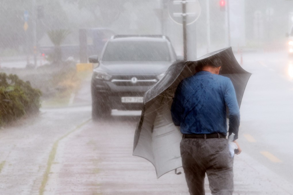 A man on South Korea’s Jeju island battles against strong wind caused by Super Typhoon Hinnamnor on Monday. Photo: Yonhap via Reuters
