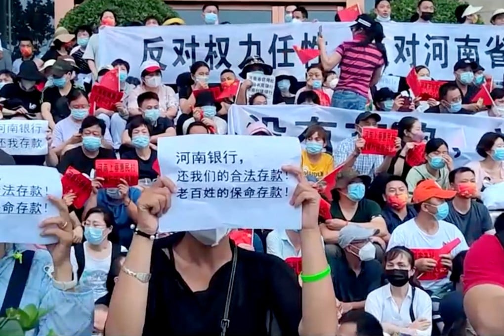 Bank customers stage a protest in Zhengzhou, Henan province, on July 10, after their funds were frozen by local banks. The sign in the foreground reads: “Henan Bank, return to us our legal deposits! The people’s life-saving deposits!” Photo: Reuters