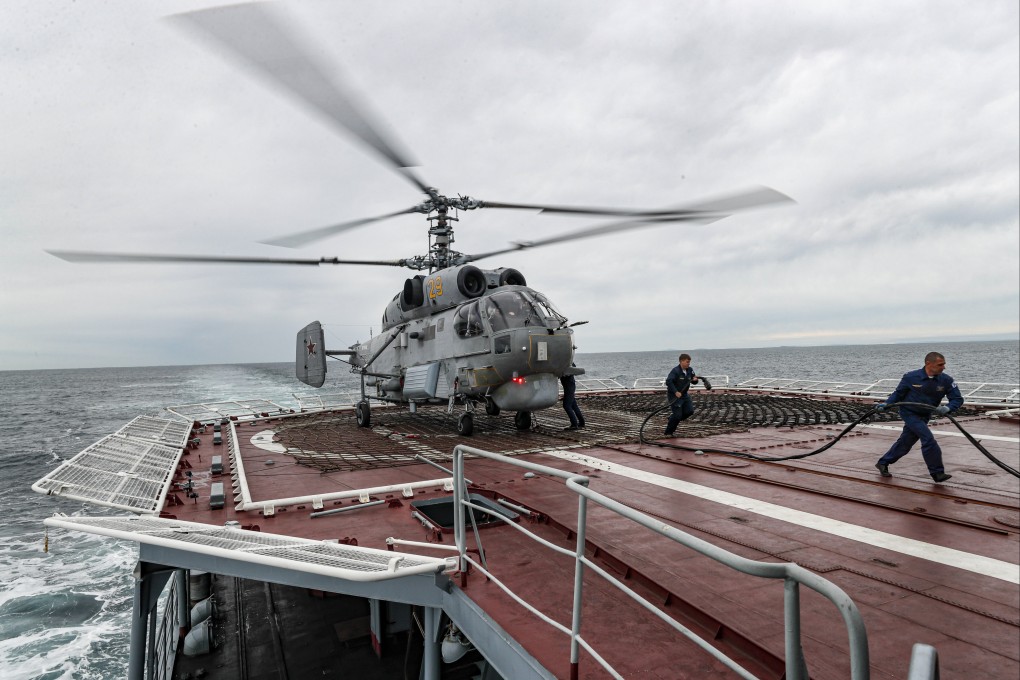 Russian Navy sailors prepare a helicopter to take off from the anti-submarine ship Marshal Shaposhnikov during the Vostok 2022 war games near Vladivostok on Monday. Photo: EPA-EFE