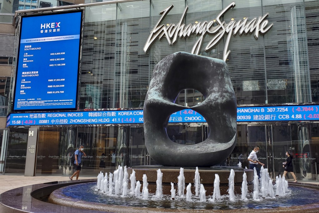 People walk past signage for Hong Kong Exchanges & Clearing displayed at the Exchange Square complex in Central. Photo: Matthew Miller
