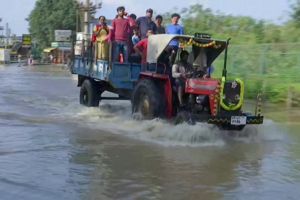 People commute in a tractor following torrential rains in Bangalore on Tuesday. Photo: Reuters