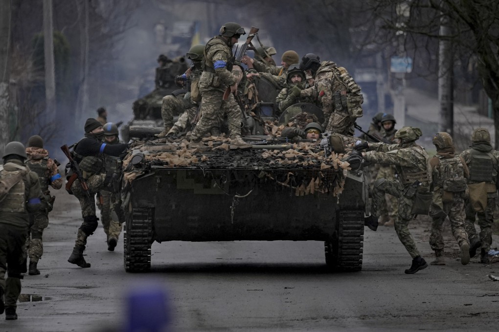 Ukrainian servicemen climb on a tank outside Kyiv. Photo: AP