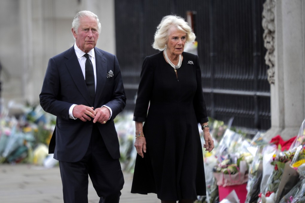 Britain’s King Charles and Camilla, the Queen Consort, look at the floral tributes left outside Buckingham Palace in London on Friday. Photo: EPA-EFE