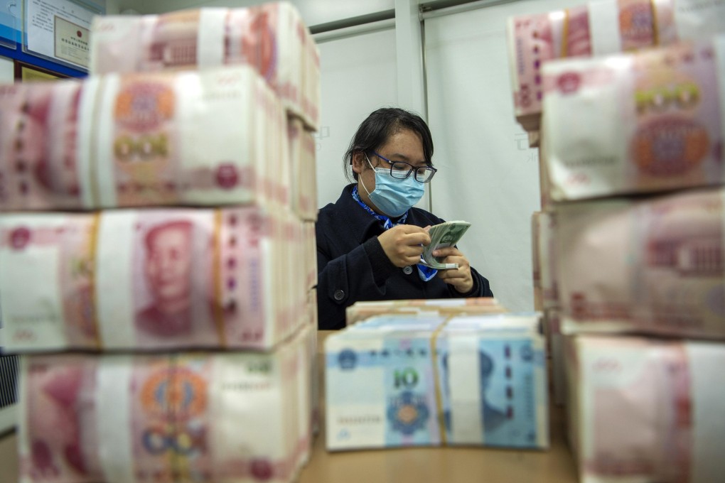 A clerk counts renminbi banknotes at a bank outlet in Hai’an city in eastern China’s Jiangsu province. Photo: AP