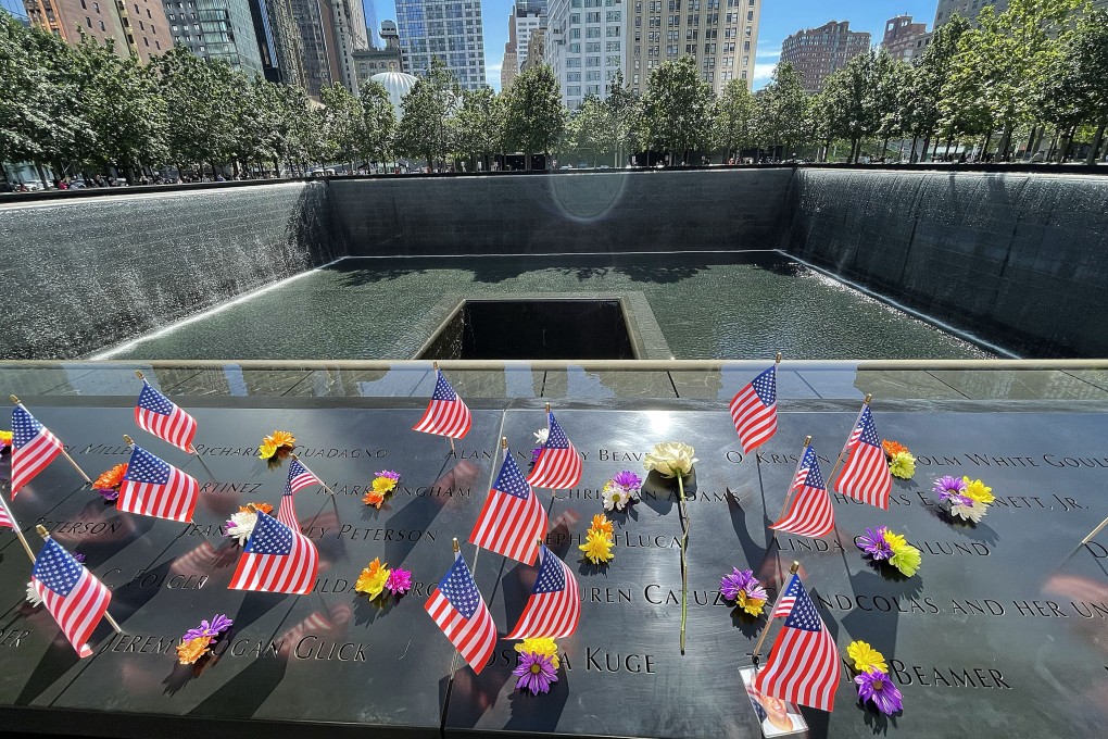 Flags and flowers lie on the names of victims to be read on metal plaques surrounding the September 11 memorial fountain in New York. Photo: dpa