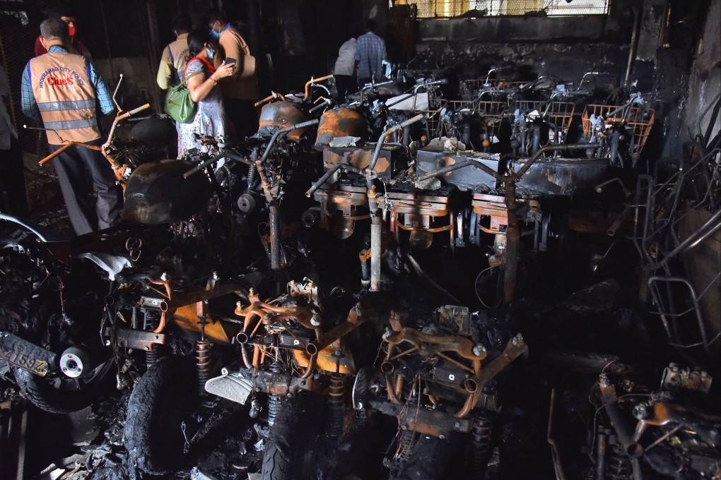 Police officials stand amid damaged scooters after a fire broke out at an electric scooter showroom in the southern city of Secunderabad, India on Tuesday. Photo: Reuters