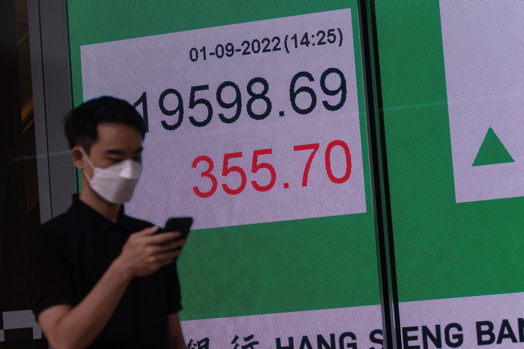 A man walks past a billboard showing the Hang Seng Index in Hong Kong on September 1, 2022. Photo: EPA-EFE