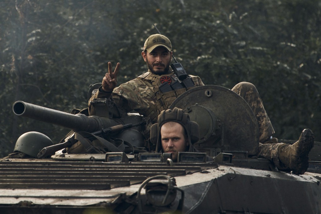 A Ukrainian soldier shows a V-sign atop a vehicle in Izium, Kharkiv region, Ukraine, on Tuesday. Photo: AP