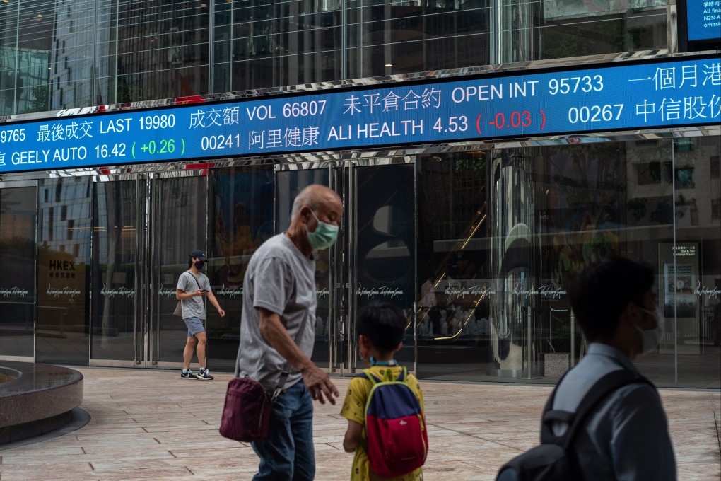 People pass a stock ticker displaying the Hang Seng Index in Hong Kong on August 29, 2022. The index gained 0.4 per cent on Thursday. Photo: EPA-EFE