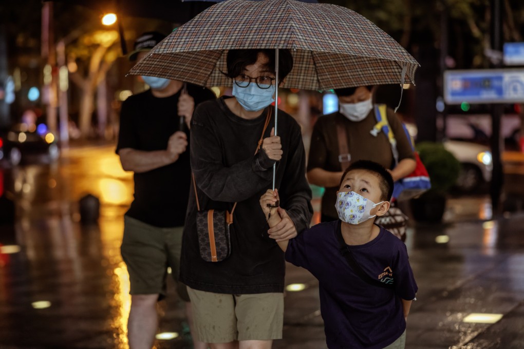 Pedestrians wearing masks walk in the rain in Shanghai on September 12. Forecasts for Chinese economic growth have been revised down, as Chinese cities continue to be placed on full or partial Covid-19 lockdown. Photo: EPA-EFE