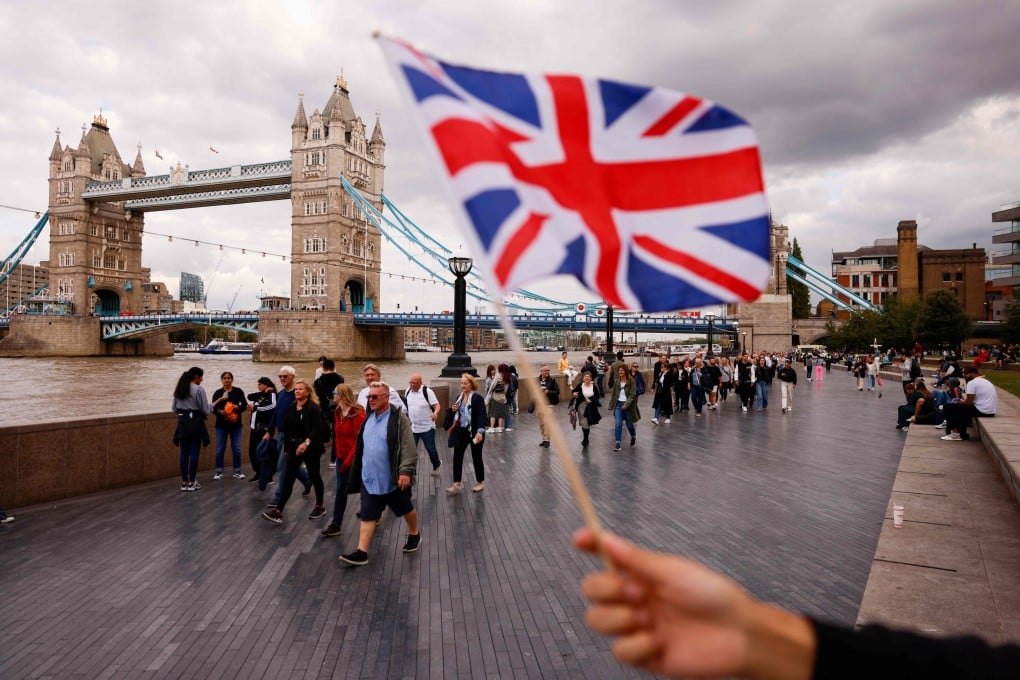 A person waves the Union flag as members of the public queue along the River Thames to pay their respects to the late Queen Elizabeth in London on Thursday. Photo: AFP