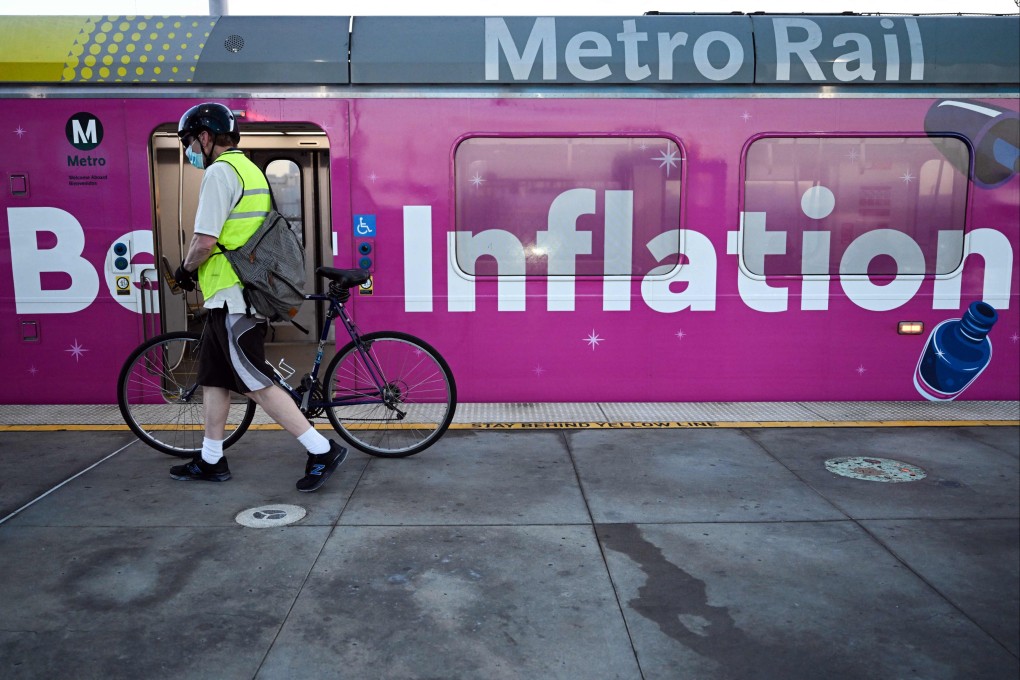 A cyclist passes a Metro green line light rail train wrapped with a “Beat Inflation” advertisement for the 99 Cents Only Stores in Redondo Beach, California, on August 31. Photo: AFP