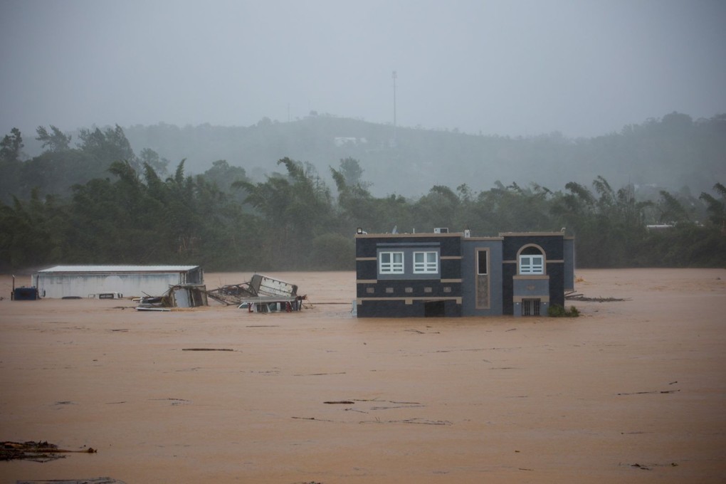 Three people inside a house await rescue from the floods caused by Hurricane Fiona in Cayey, Puerto Rico. Photo: AP