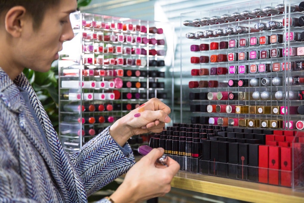 Beauty blogger Austin Li Jiaqi applies lipsticks on his hands on January 3, 2018 in Shanghai, China. Photo by VCG/VCG via Getty Images