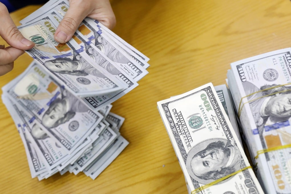A bank employee counts US dollars in Hanoi. Many countries and companies, especially in the developing world, borrow in dollars. Photo: EPA-EFE
