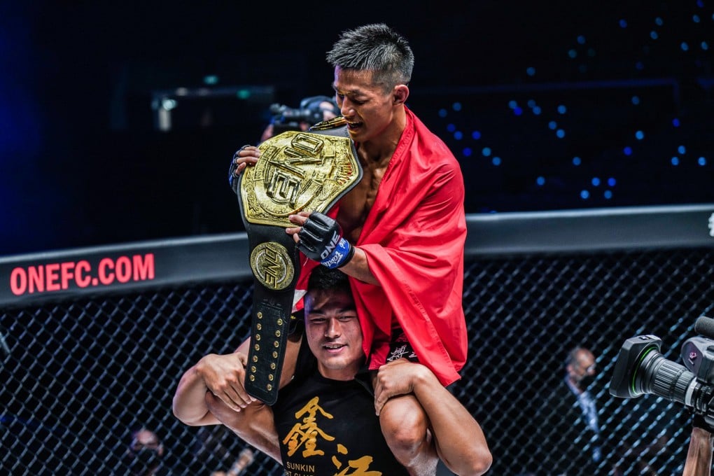 Tang Kai celebrates with the ONE Championship featherweight title after beating Thanh Le in Singapore. Photo: ONE Championship