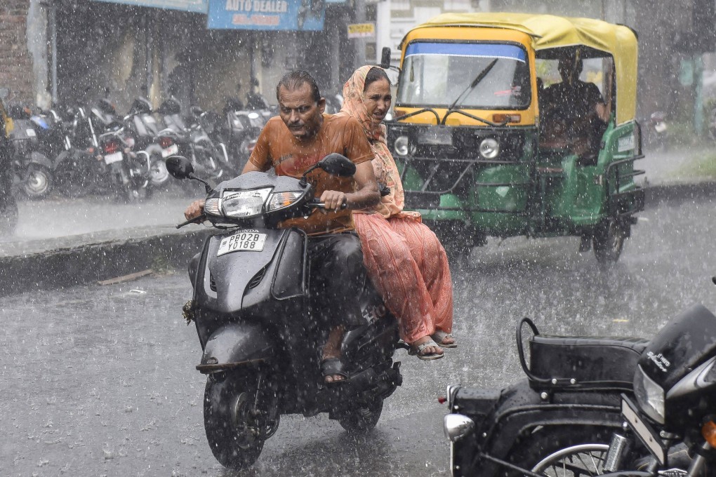 Commuters make their way along a road during a heavy rainfall in Amritsar in India on September 23, 2022. Photo: AFP