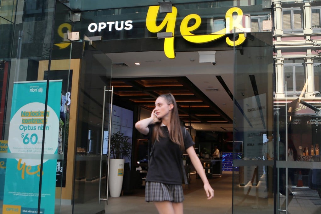 A woman uses her mobile phone as she walks past an Optus shop in Sydney, Australia, in 2018. File photo: Reuters