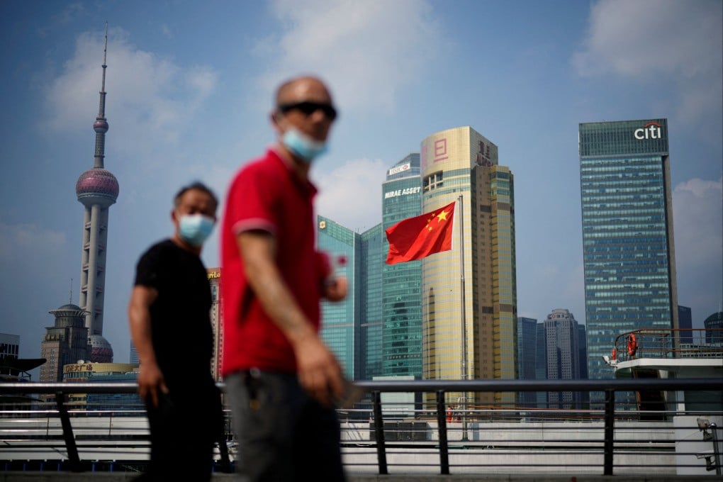 People walk past a Chinese flag in Shanghai on August 2, 2022. Photo: Reuters