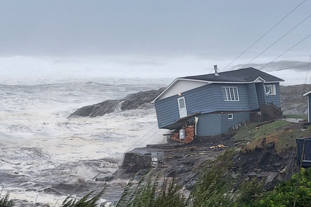 Waves roll in near a damaged house built close to the shore in Newfoundland and Labrador. Photo: Wreckhouse Press/Handout via Reuters