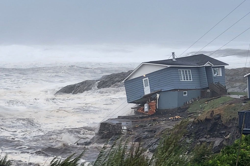 Waves roll in near a damaged house built close to the shore in Newfoundland and Labrador. Photo: Wreckhouse Press/Handout via Reuters